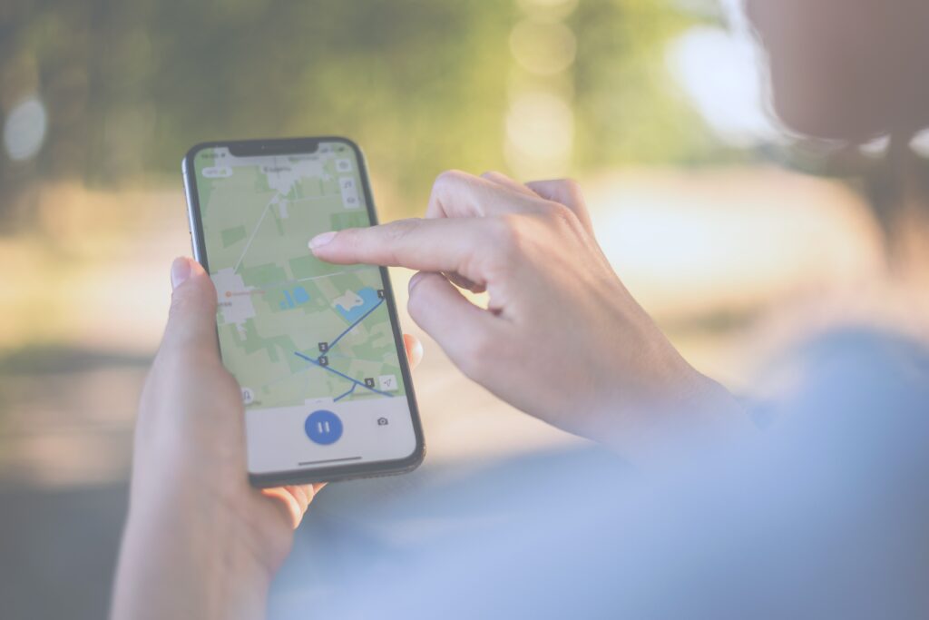 girl looks at a map on her phone and plots a route for a trip for a GPS navigator. 